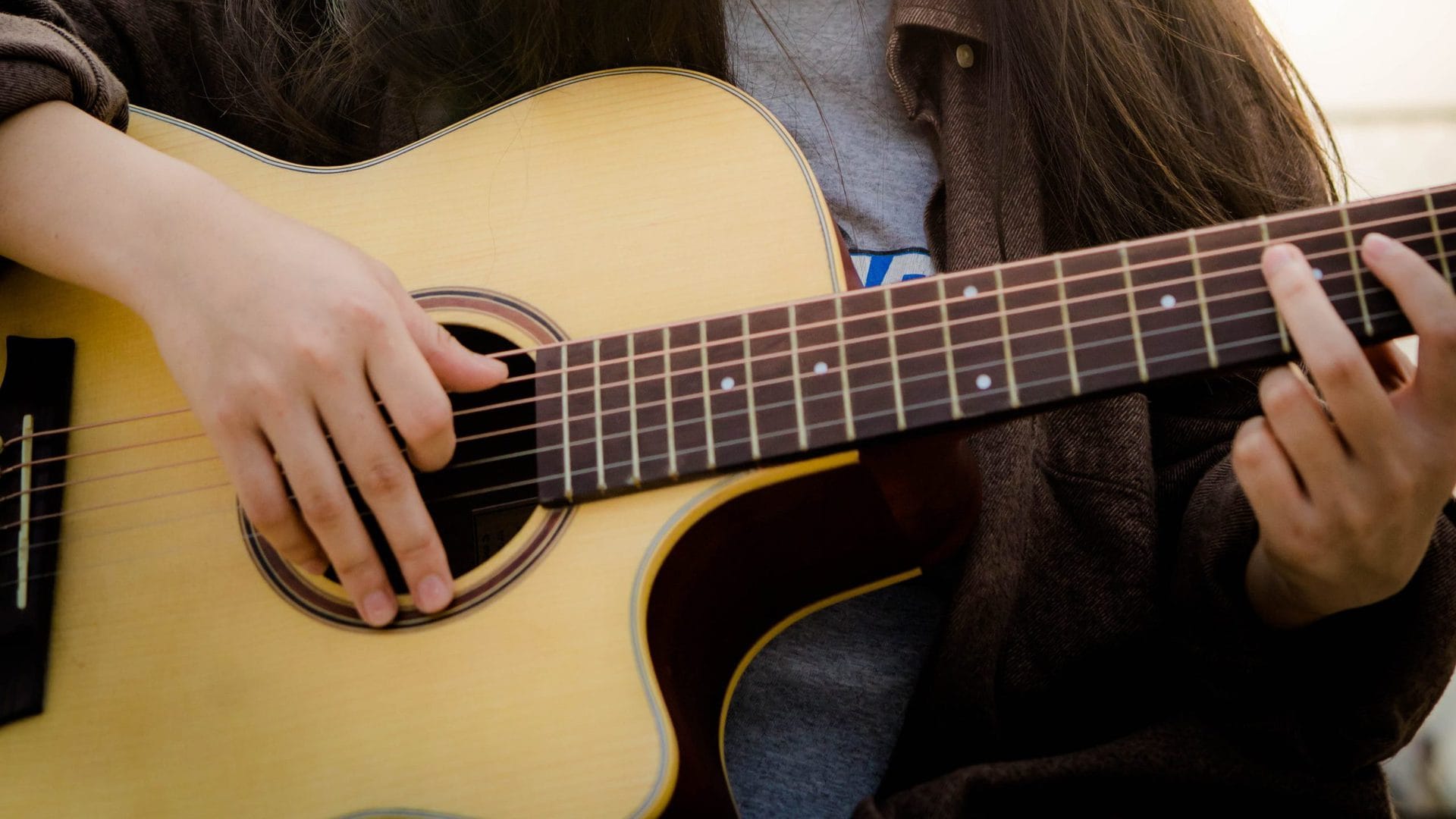 A young person plays guitar, probably in DADGAD. 