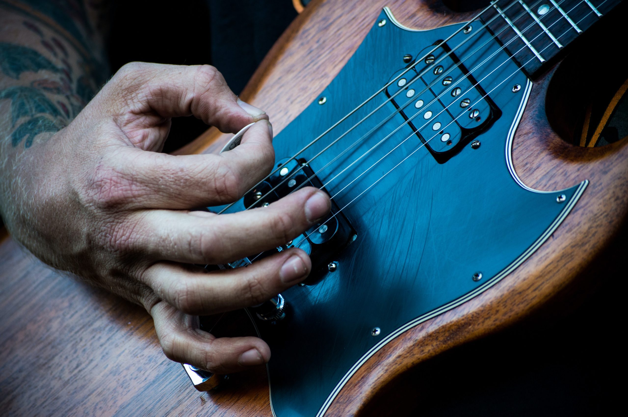 Close-up photo of an SG style guitar being played.